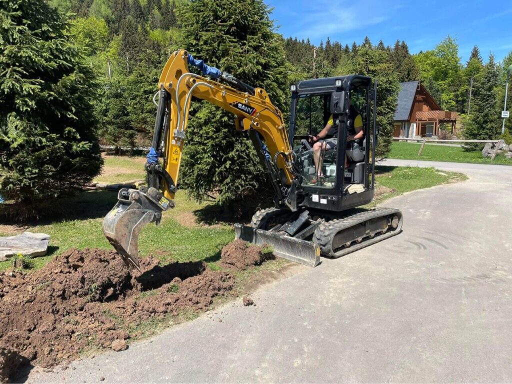 Bager pracuje na vykopávaní základového pasu pre plot. Tento dôležitý krok v procese výstavby zabezpečuje pevnú podporu a stabilitu pre budúci plot. S našimi profesionálnymi službami môžete mať istotu kvalitného a spoľahlivého výsledku vo vašom stavebnom projekte